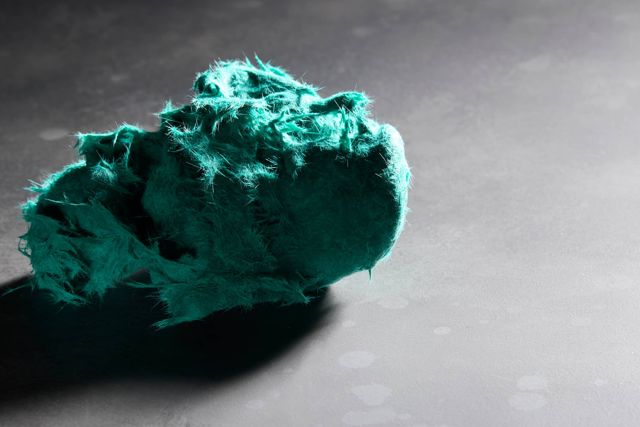 Macro view of teal fibrous phenolic molding compound or bulk thermoset material.