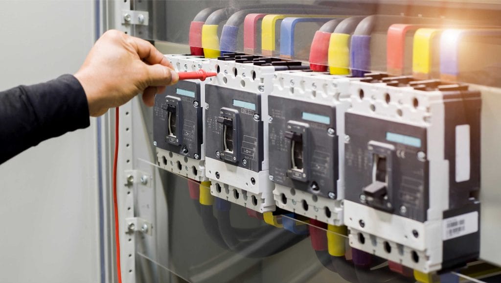 n electrician testing industrial circuit breakers that utilize PLENCO high-performance thermoset materials.
